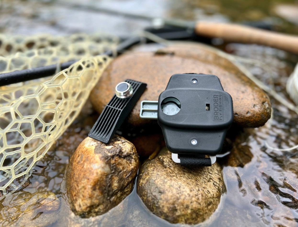 Broder Net Clip and magnetic net mount shown beside a landing net for secure fly fishing net storage and quick release
