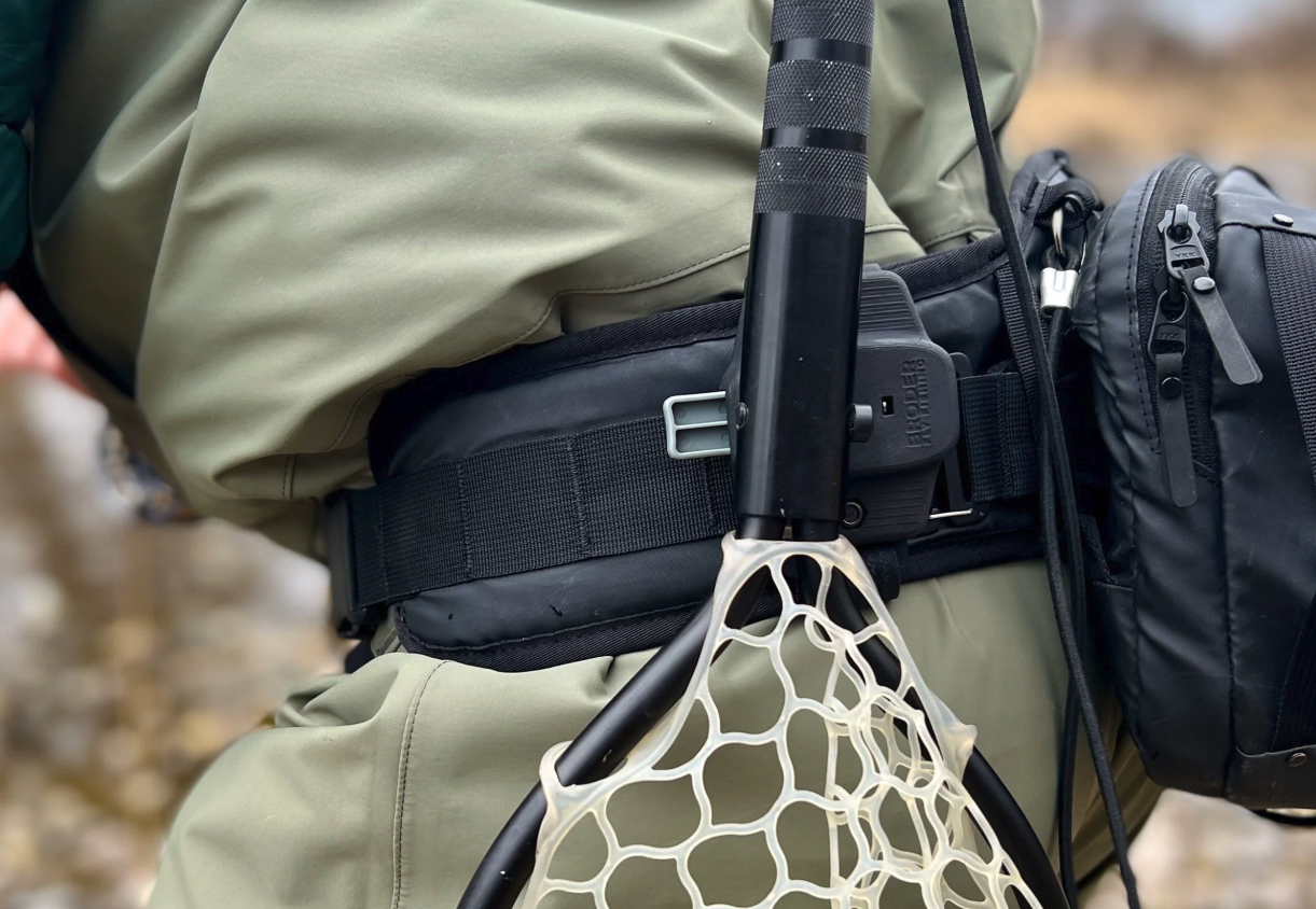 Broder Net Clip mounted on a wading belt with landing net secured behind the hip for quick one-handed fly fishing access