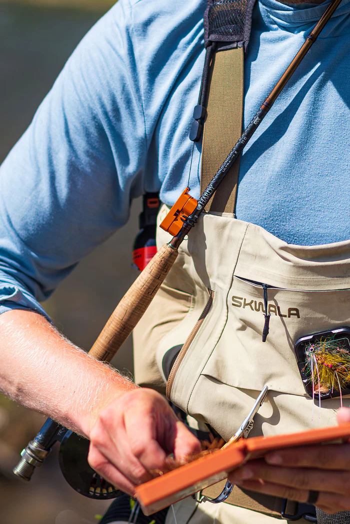 Angler using the Cling Mag Grab Rod Rack on his waders to hold a fly rod