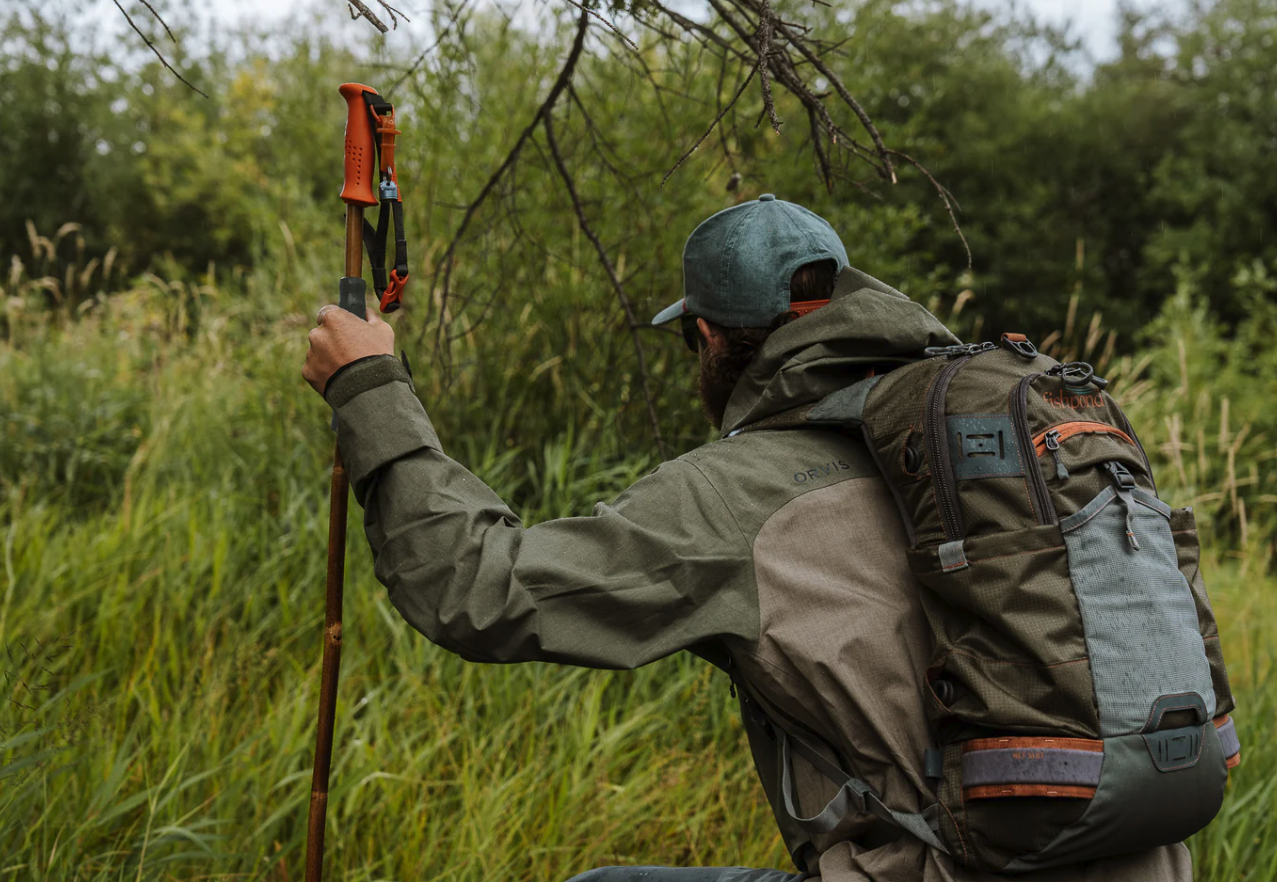 Angler with backpack holding up Fishpond Grass Sticks Wading Staff
