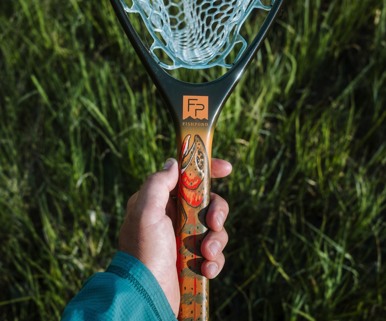 Hand holding Fishpond Nomad Canyon Net Colorado Cutty edition.