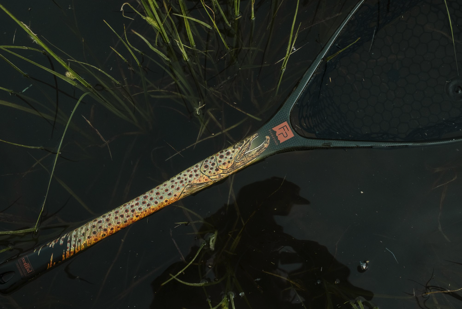 Fishpond Nomad Middle Fork Net Hook Jaw Limited Edition floating in water