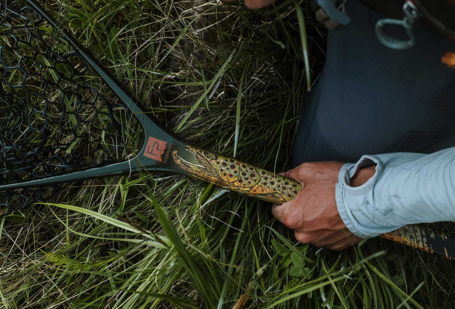 Man holding Fishpond Nomad Middle Fork Net Hook Jaw Limited Edition