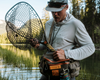 Angler holding Fishpond Nomad Middle Fork Net Hook Jaw Limited Edition by hip pack