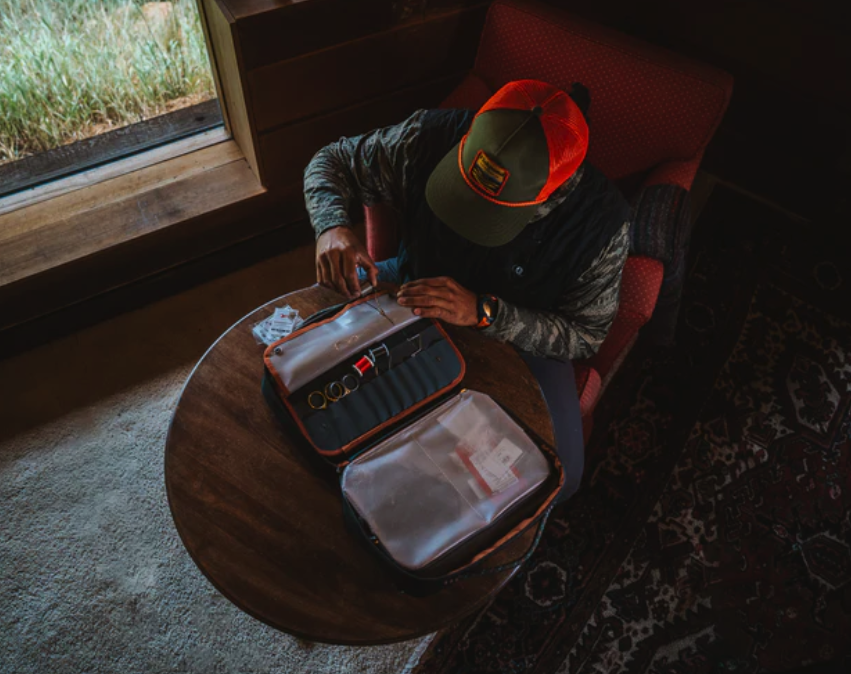 Man tying flies with Fishpond Backwater Fly Tying Kit on desk