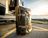 Side view of Fishpond Stormshadow Medium Rolling Duffel by ocean
