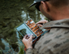 Angler picking fly from  Tacky Original Fly Box Burnt Orange