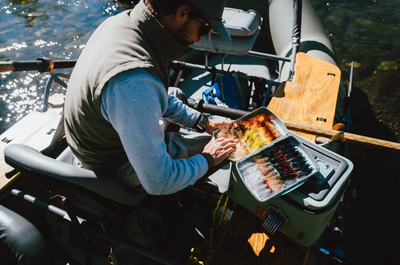 Man in drift boat selecting fly from Fishpond Tacky Pescador Dynamic Foam Fly Box XL