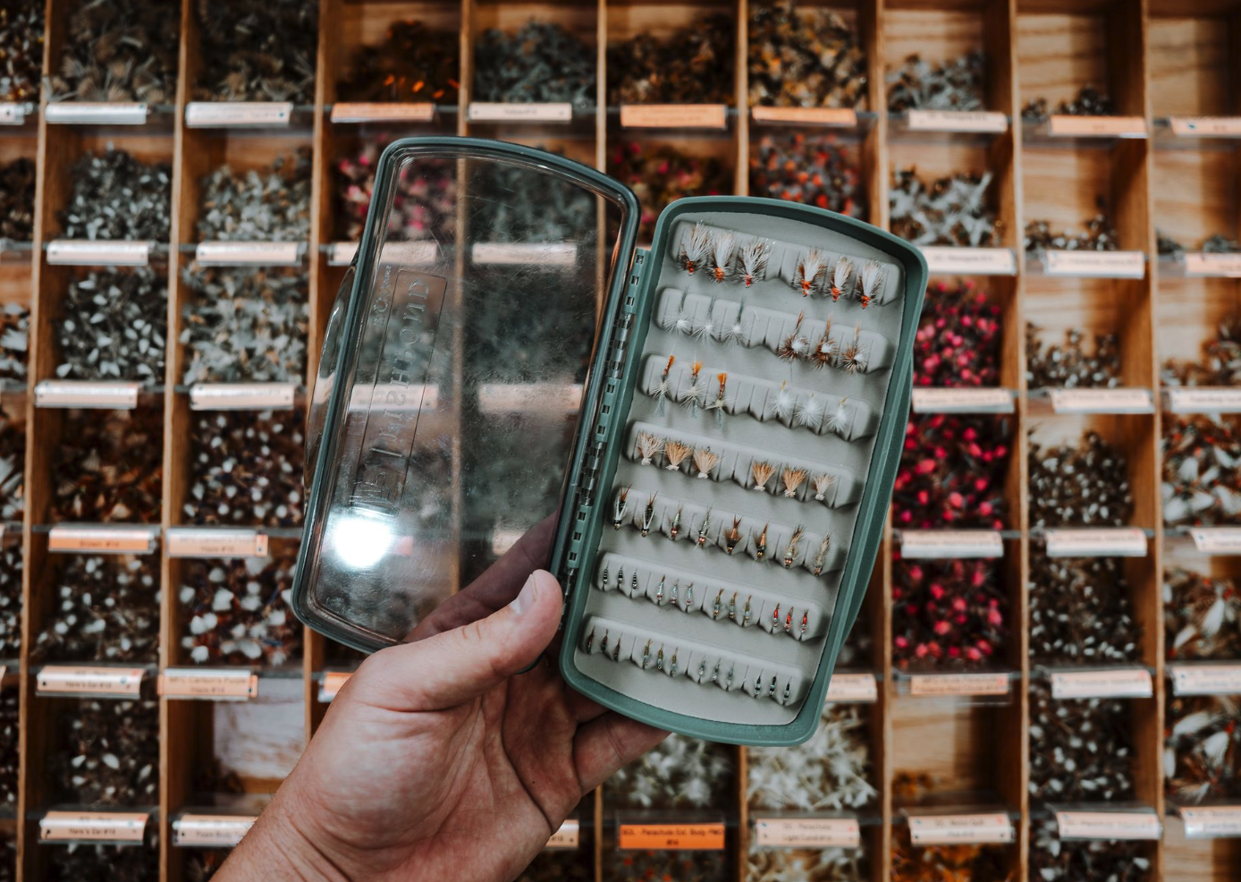 Fishpond Tacky Pescador LowPro Clear Medium Fly Box open and filled near fly shop fly bins