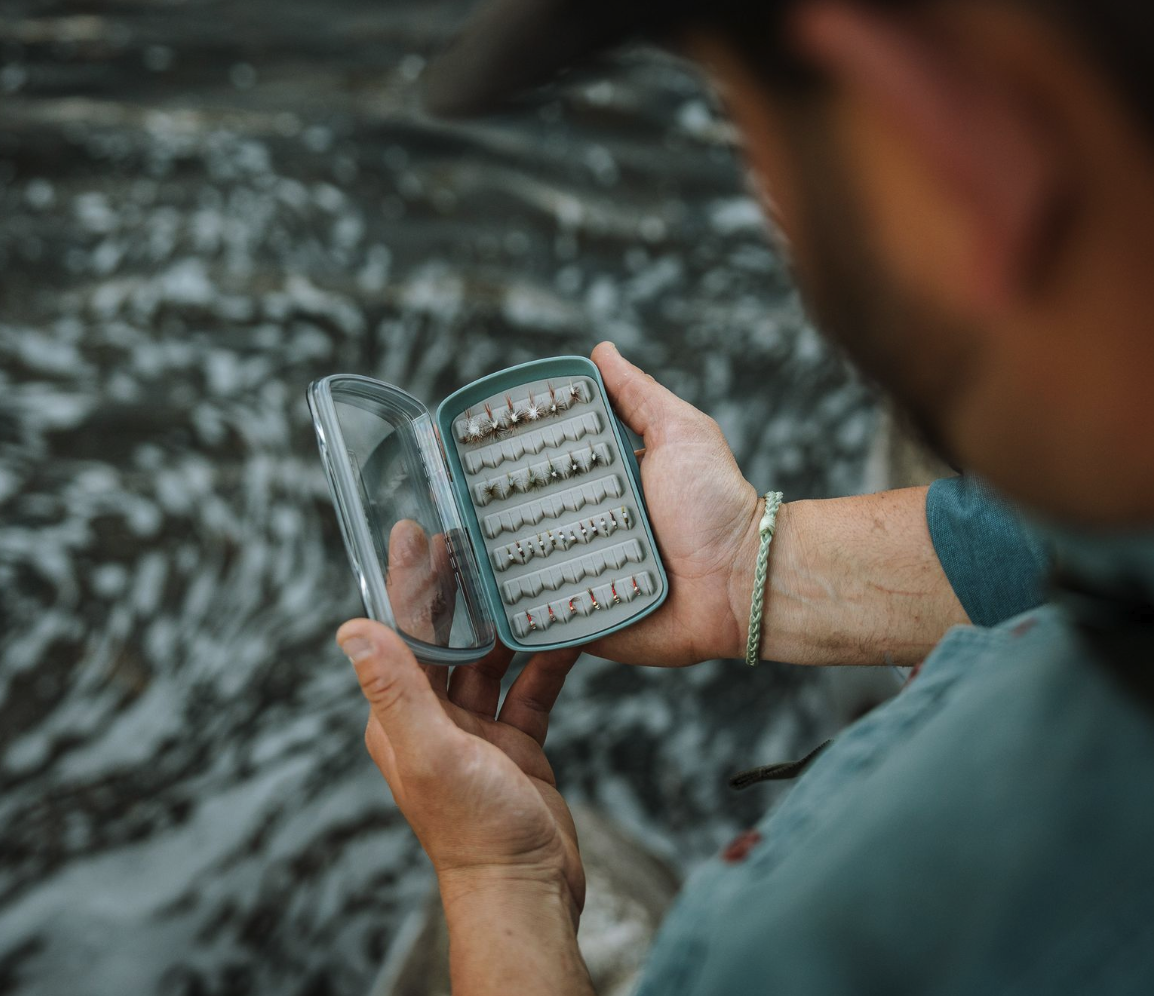 Man looking at Fishpond Tacky Pescador LowPro Clear Small Fly Box on river