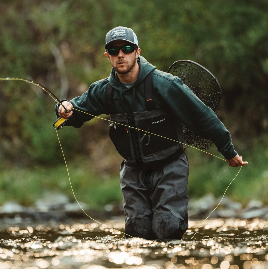 Angler casting fly rod while wearing Grundens Vector Zip Waders