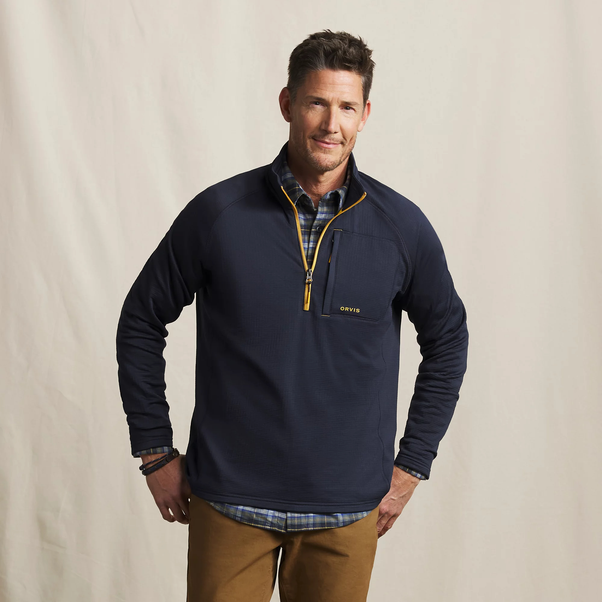 Men's Orvis Horseshoe Hills navy fleece quarter zip layered over a plaid shirt for cool-weather fishing and camping