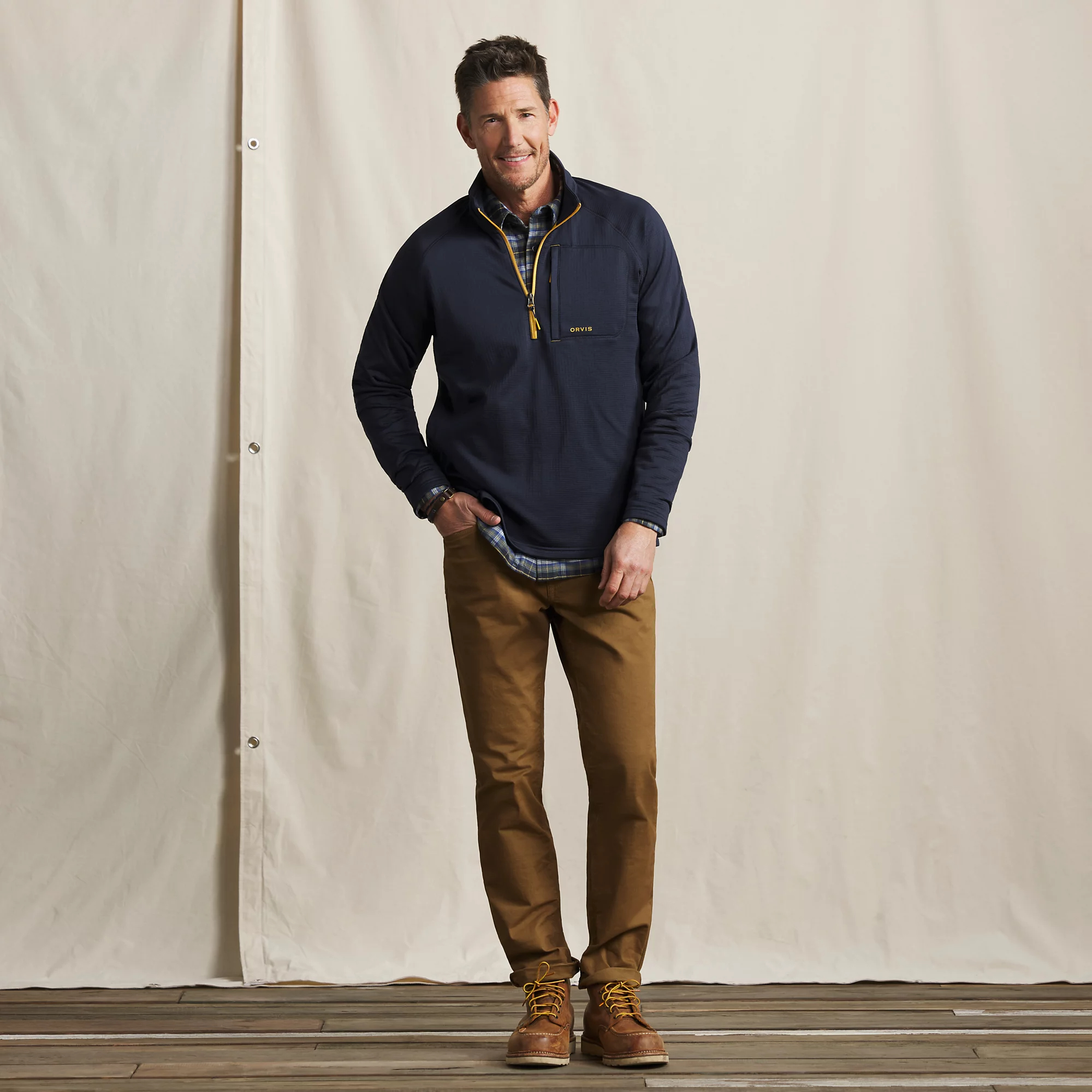 Full-length view of men's Orvis Horseshoe Hills quarter zip fleece worn over flannel for casual outdoor and fishing wear