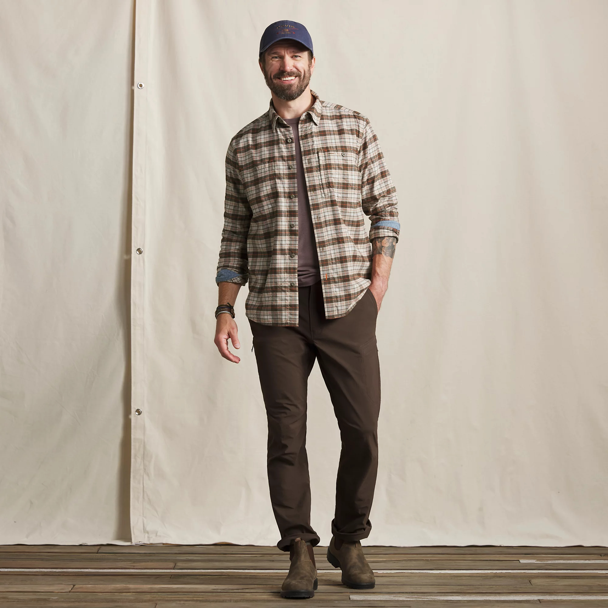 Men's Orvis Flat Creek Tech Flannel fishing and camping shirt in earth-tone plaid worn as a casual outdoor layer.