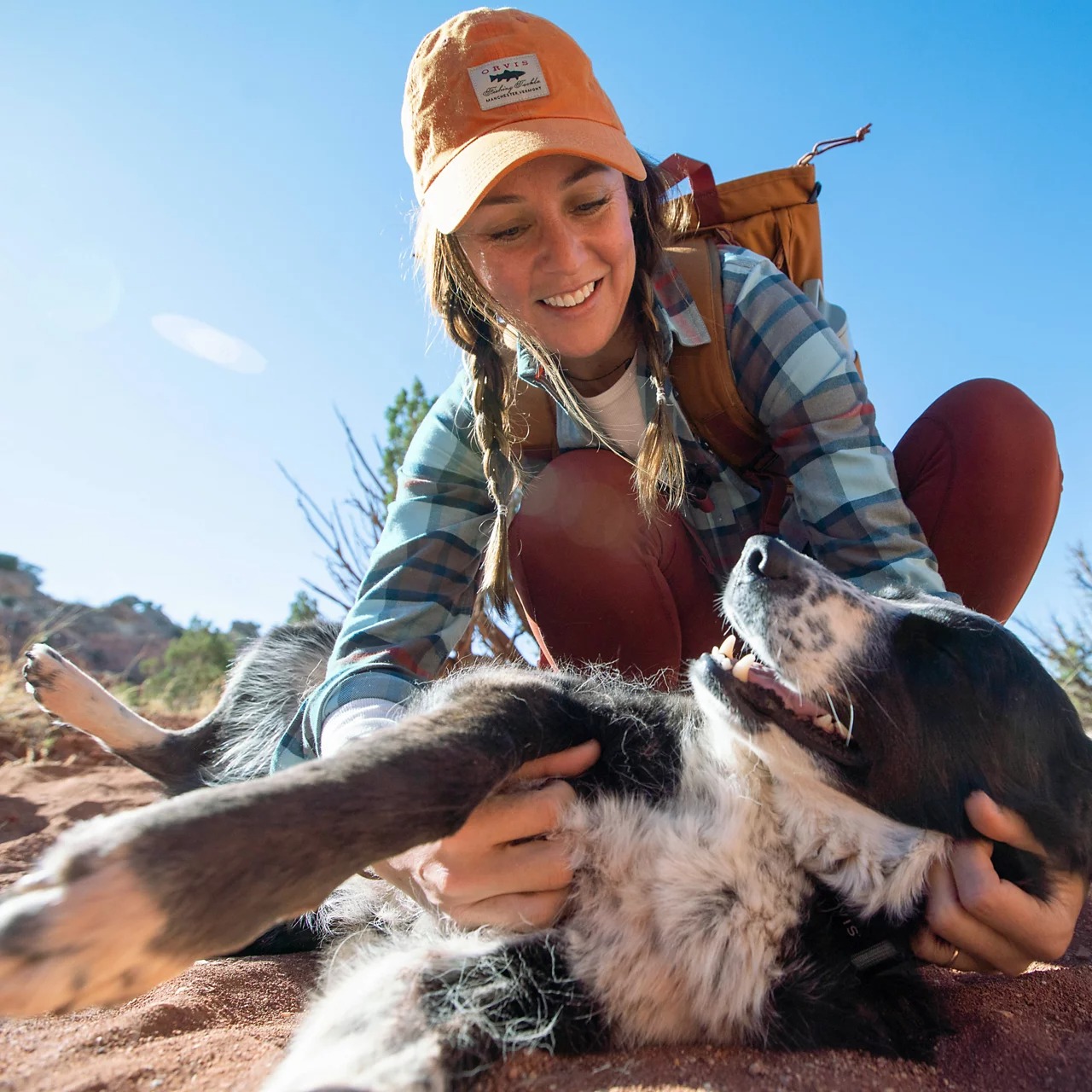 Orvis Vintage Waxed Cotton Ball Cap Burnt Orange worn by woman outdoors with her dog, featuring classic fishing hat styling