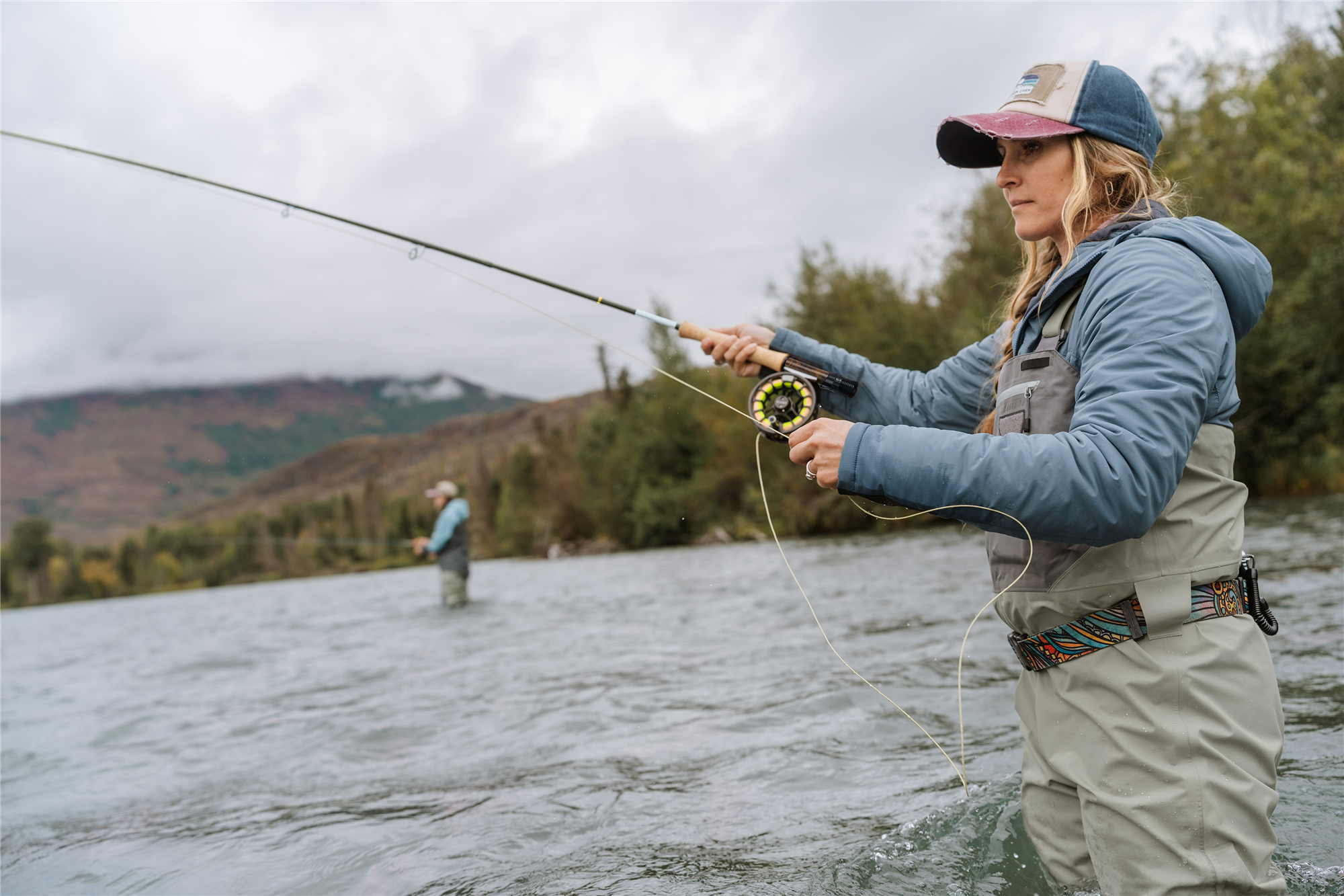 Angler fly fishing in river with Orvis Hydros large arbor fly reel trout fly fishing setup