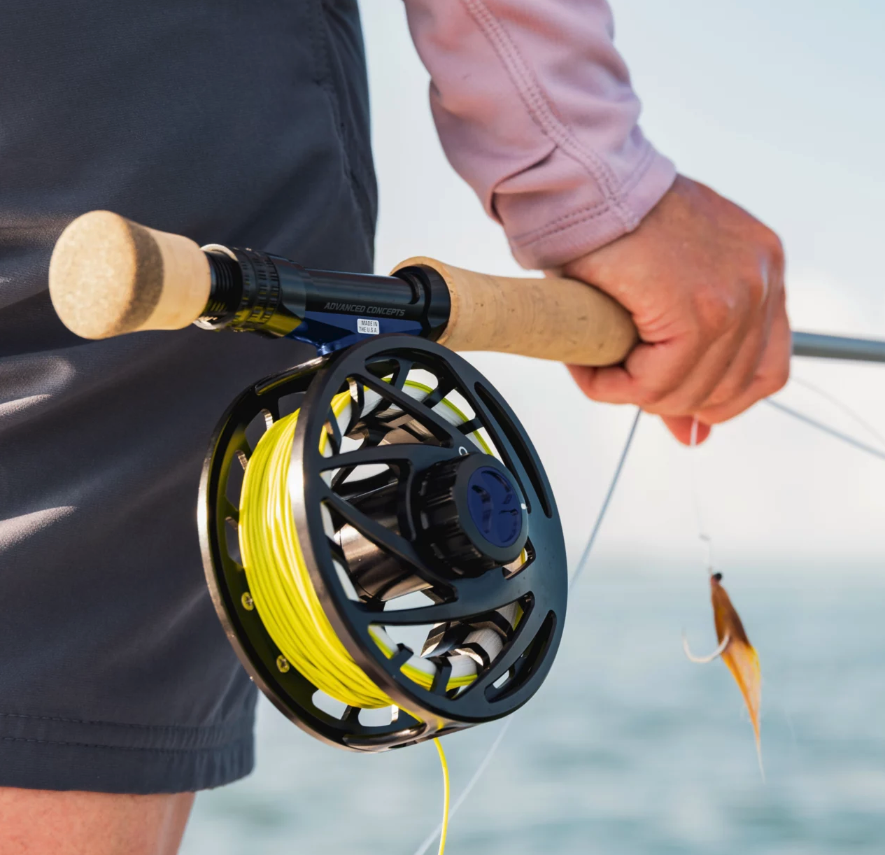 Angler holding fly rod with  Orvis Mirage Reel Blackout on it.