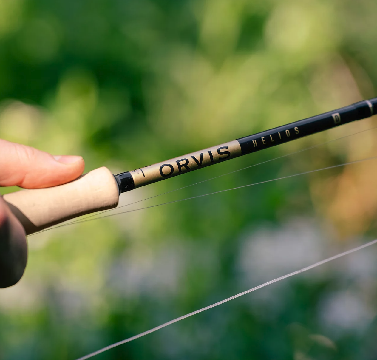 Hand holding Orvis Helios D Limited Edition 50th Anniversary Fly Rod outside
