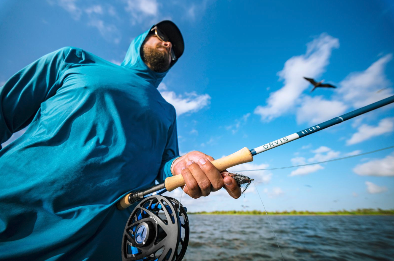 Angler holding Orvis Recon Saltwater Fly Rod and reel while fishing