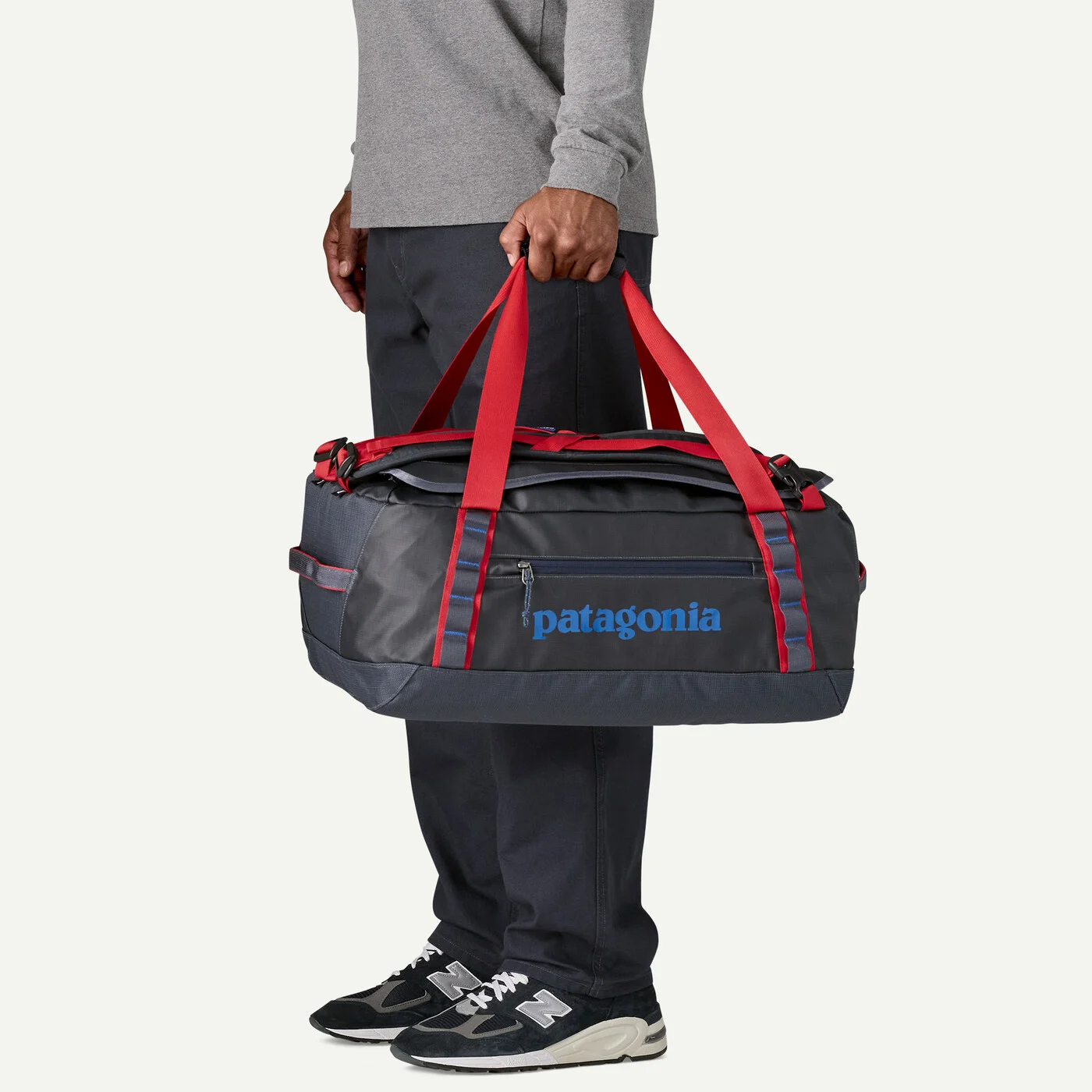 Traveler carrying the Patagonia Black Hole Duffel 40L by reinforced handles for weekend and outdoor adventures