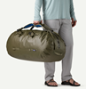 Man holidng Patagonia Guidewater Duffel 80L at side