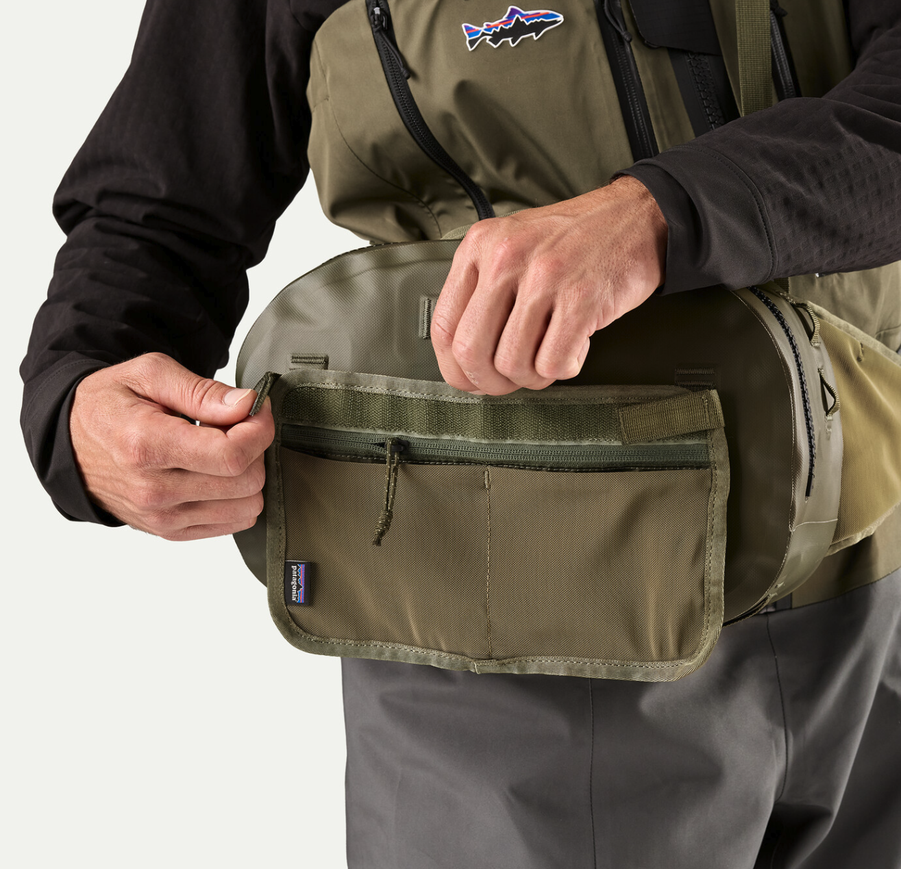 Angler wearing and opening  Patagonia Guidewater Hip Pack Basin Green