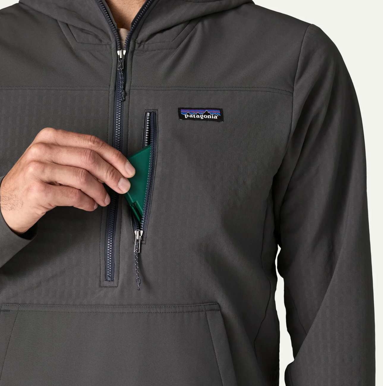 Phone being put into chest pocket of Patagonia R2 TechFace Pullover