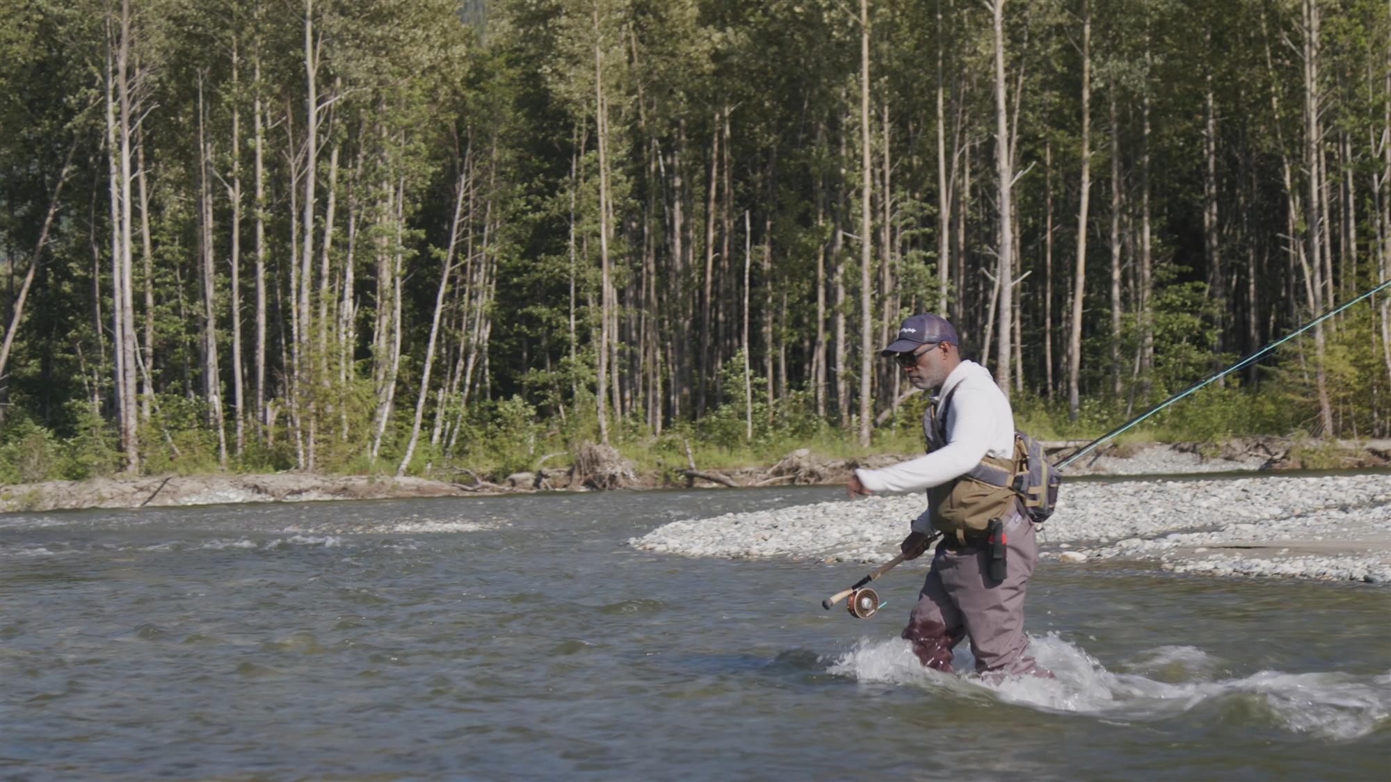 Fly Fisherman Walking Across A River Wearing Patagonia's Swiftcurrent Expedition Zip-Front Wader