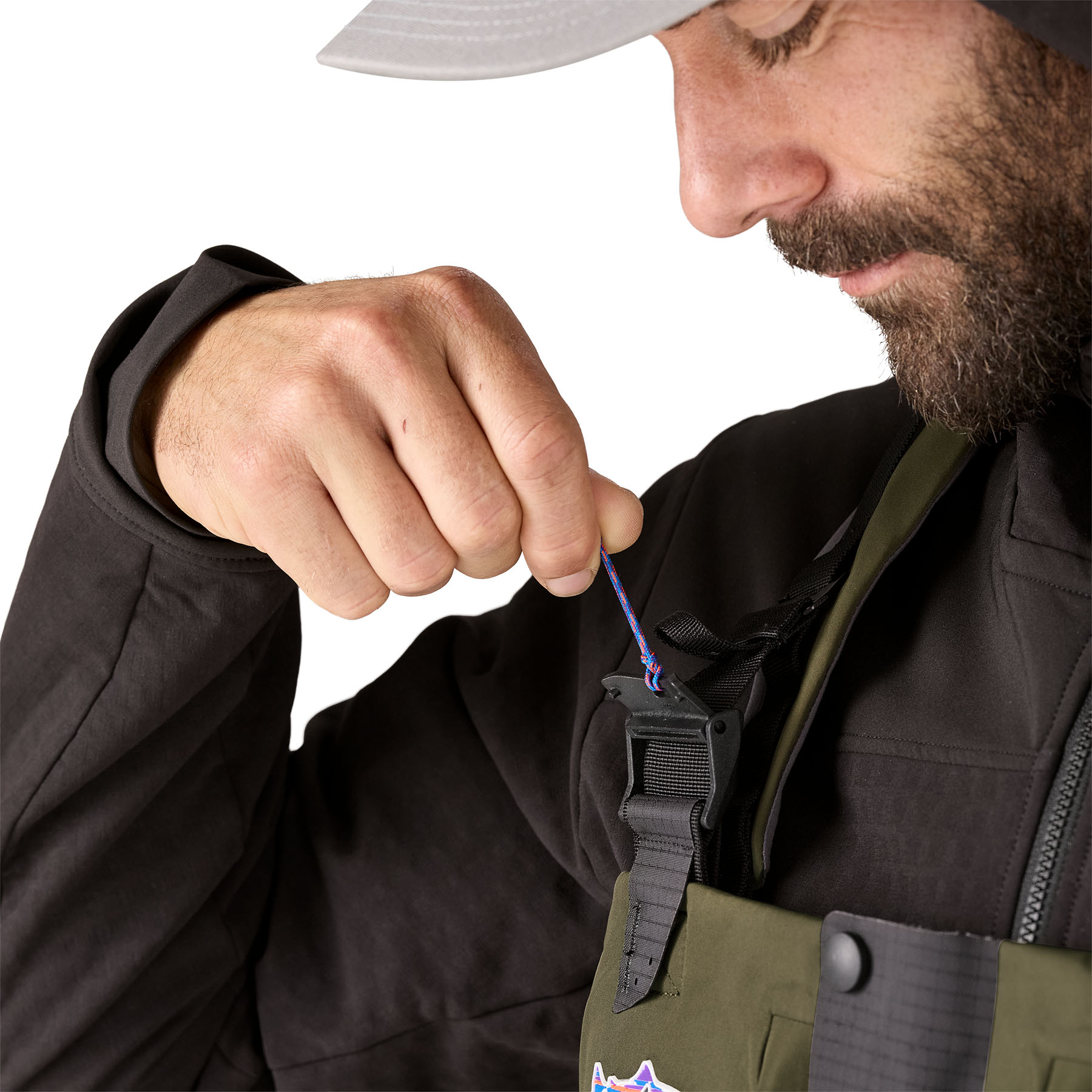 Model highlighting the clasp for Patagonia's Swiftcurrent Expedition Zip-Front Wader suspender system
