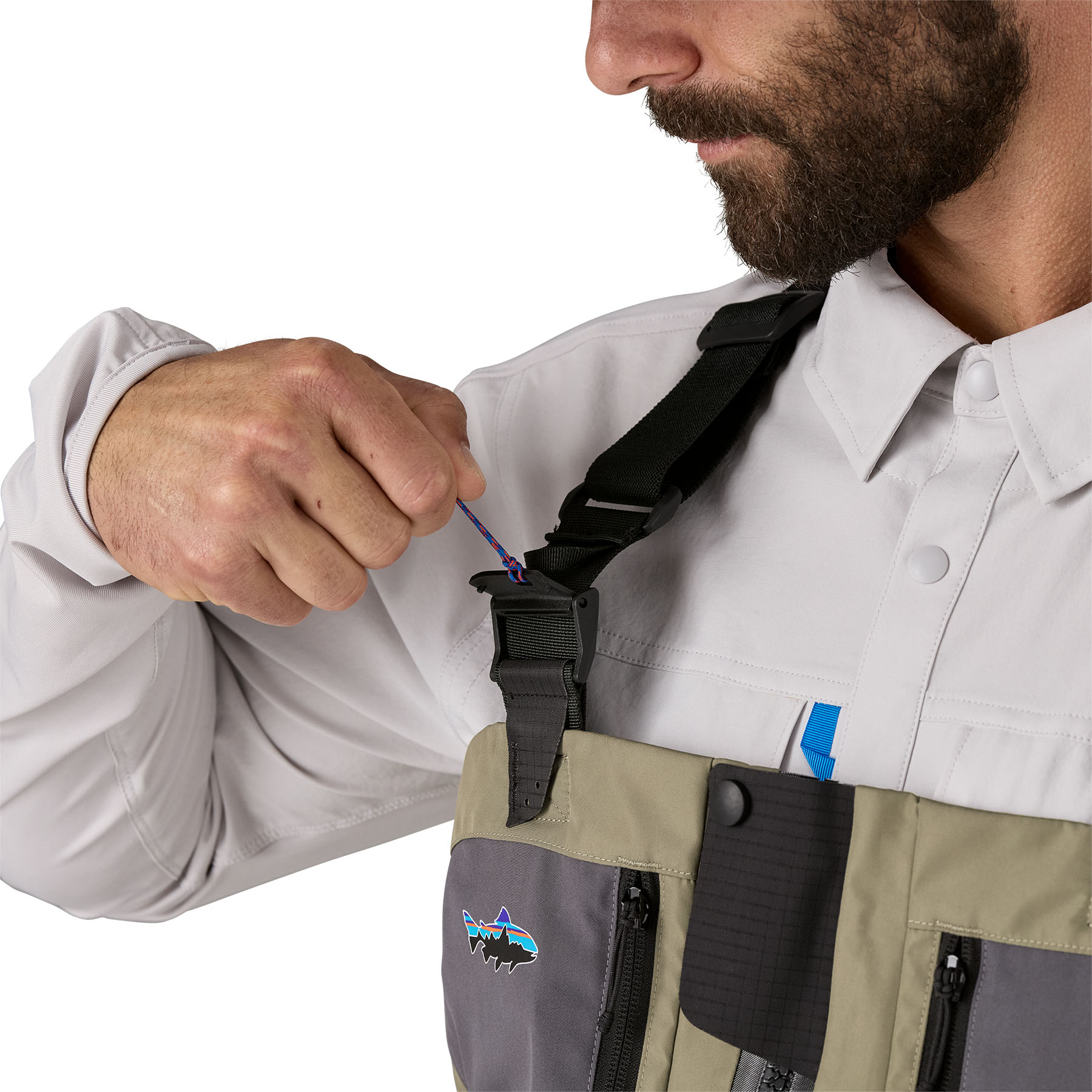 Model highlighting the clasp for Patagonia's Swiftcurrent Traverse Zip-Front Wader suspender system