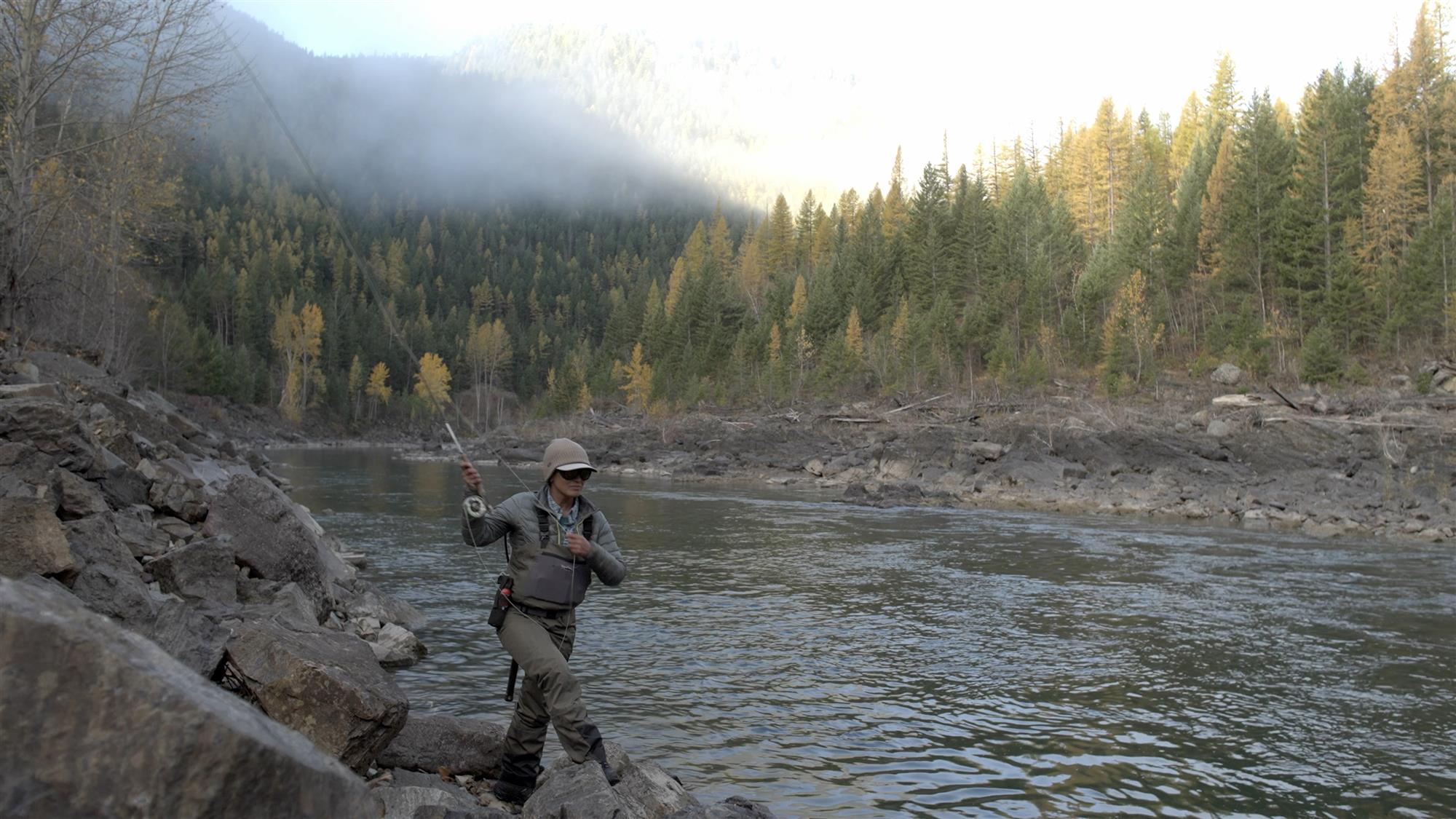 Female angler using the Patagonia Women's Swiftcurrent Traverse Waders on a river