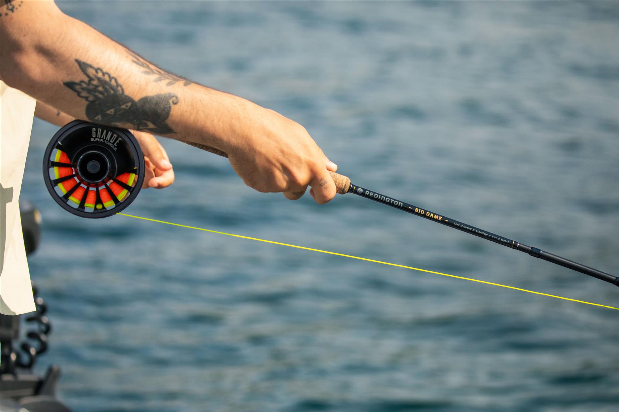 Angler holding Redington BIG GAME Fly Rod with Redington Grande fly reel and fishing