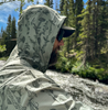 Angler with hood up wearing  Rep Your Water Flolite Sun Hoody Spring Forest color