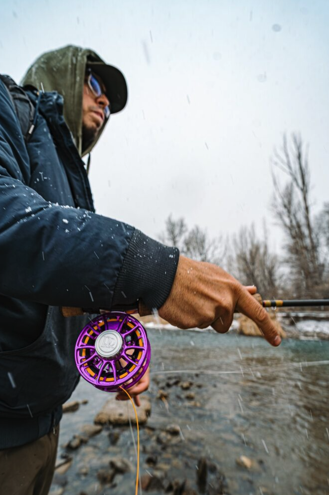Angler fishing with Ross Reels Animas Fly Reel Purple Limited Edition on river