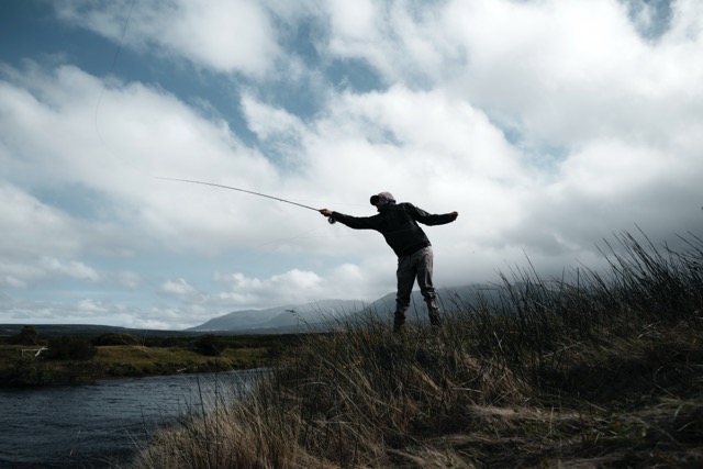 Angler casting Sage R8 POWER Fly Rod into river