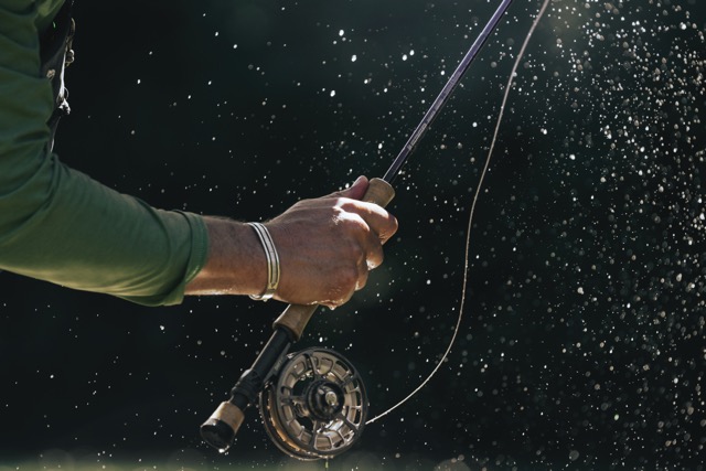 Angler holding Sage R8 POWER Fly Rod with Sage fly reel