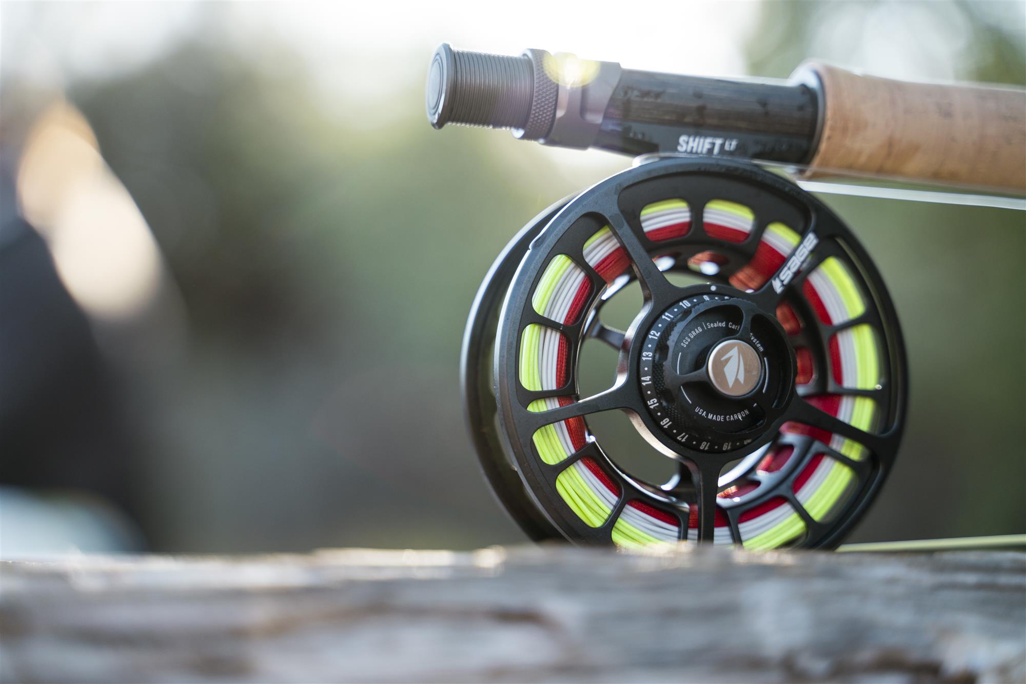 Sage SHIFT LT fly fishing reel on a fly rod in soft sunrise light—large arbor reel with bright fly line and backing