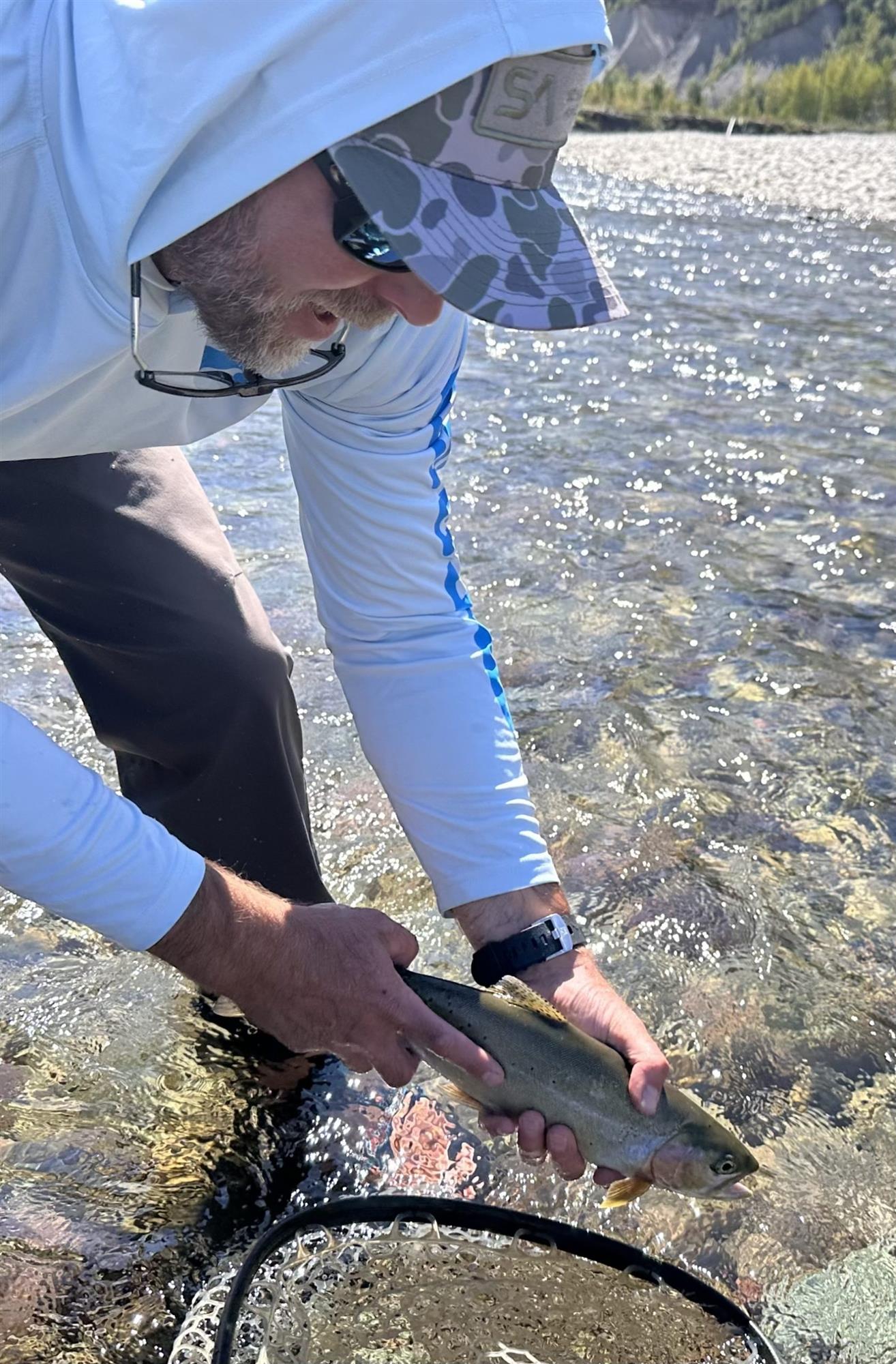 1. Scientific Anglers Camo Trucker Hat worn by angler while trout fishing in a river