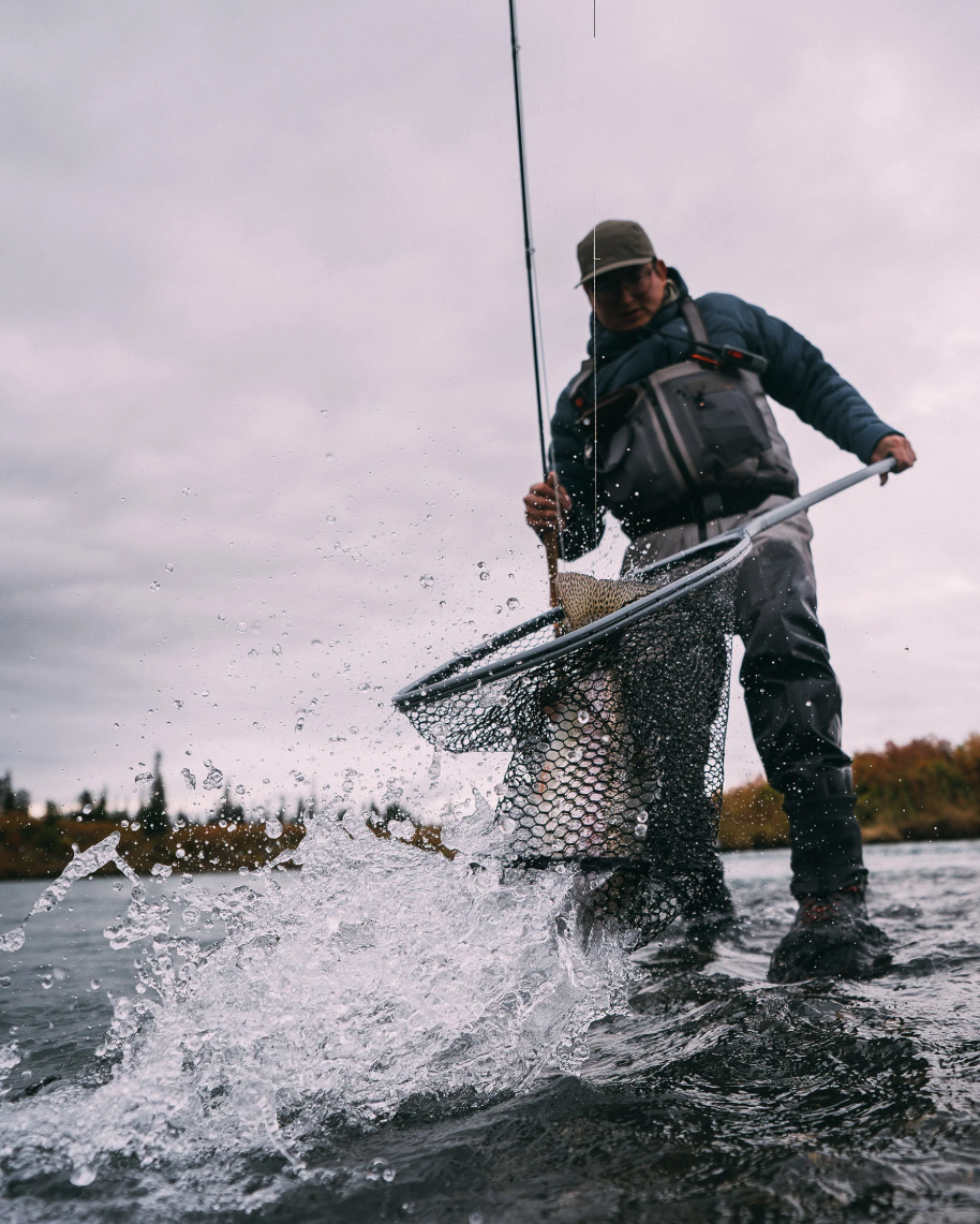 Angler landing trout in Simms Daymaker Boat Net Short Handle