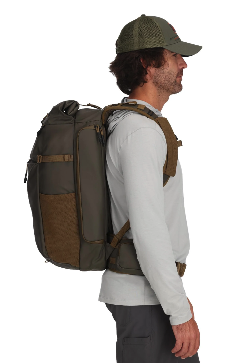 Side view of model wearing Simms Headwaters Backpack