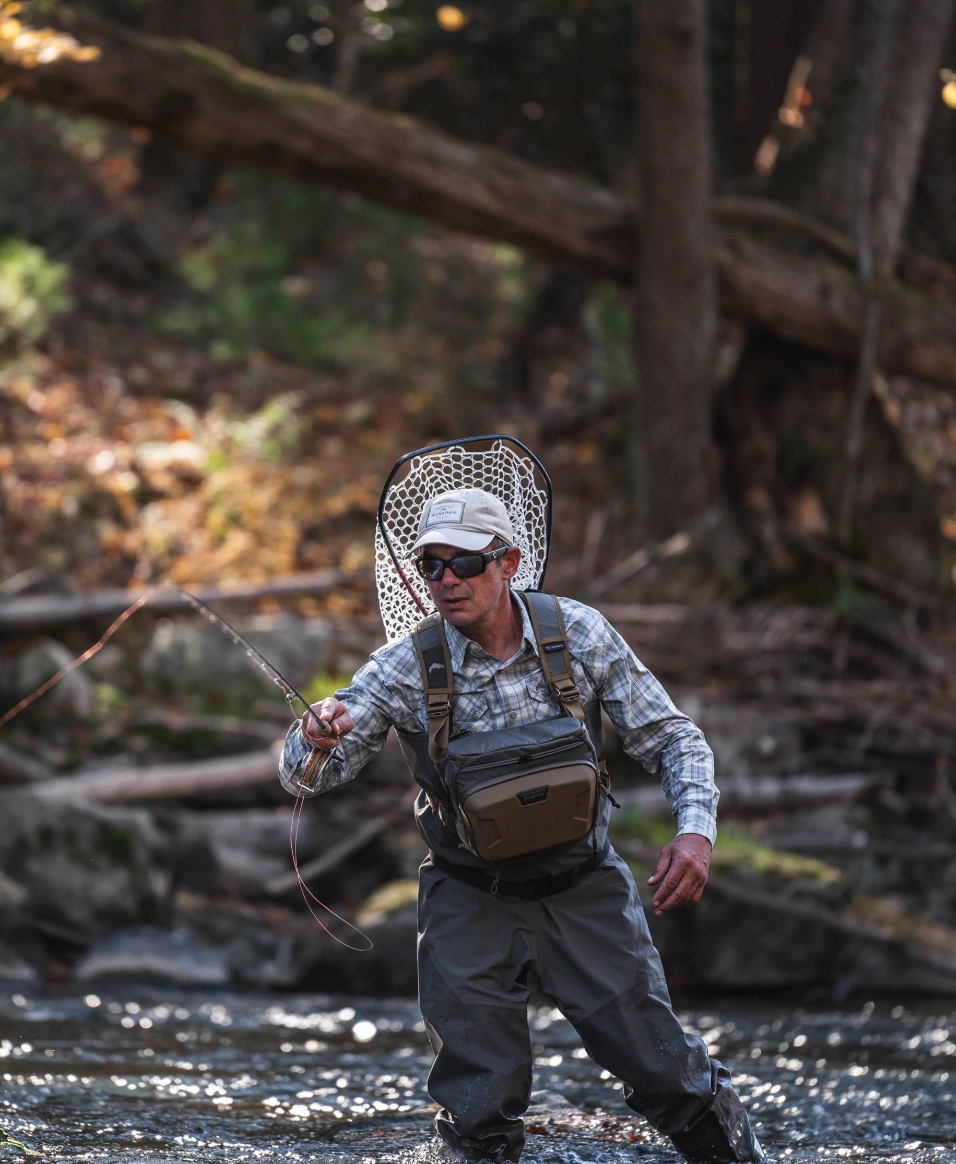 Fly Fisherman fishing while wearing the Simms Headwaters Chest Pack Hickory color.