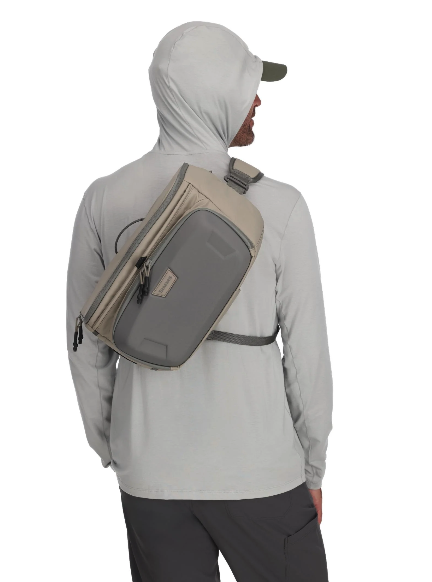 Back of model wearing Simms Headwaters Sling Pack Dolomite color.