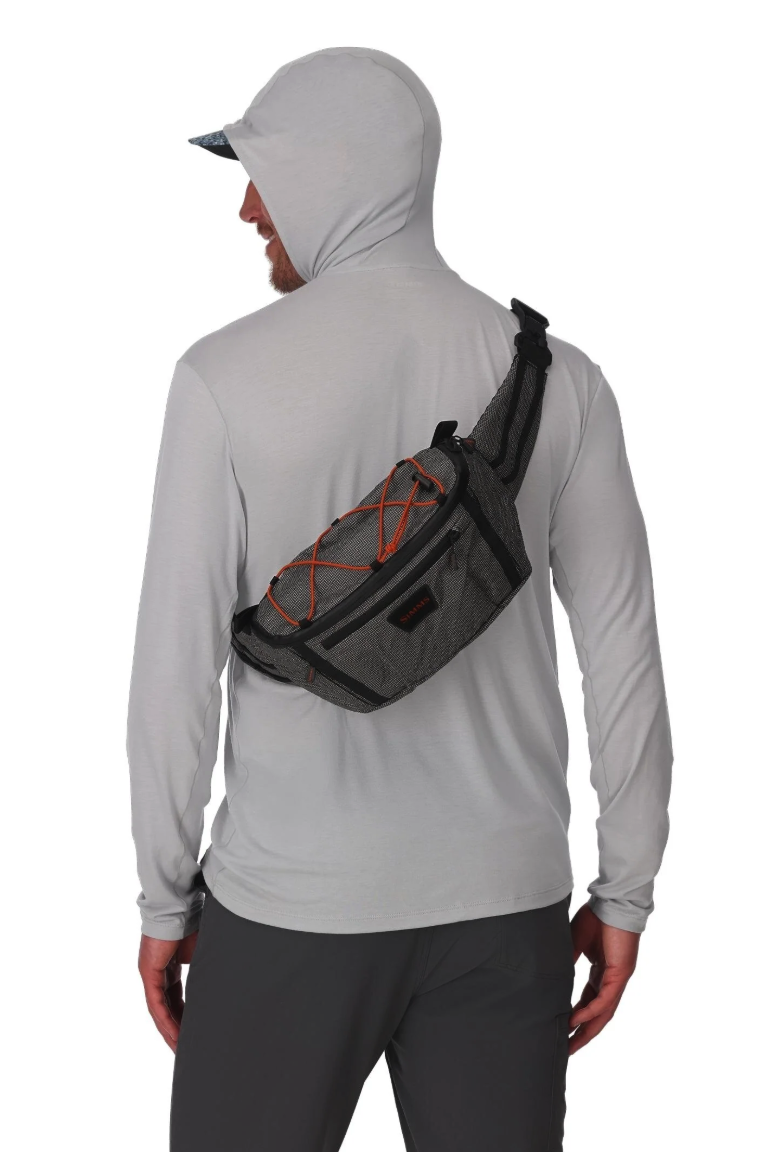 Model wearing sling Simms Scout Hip Pack