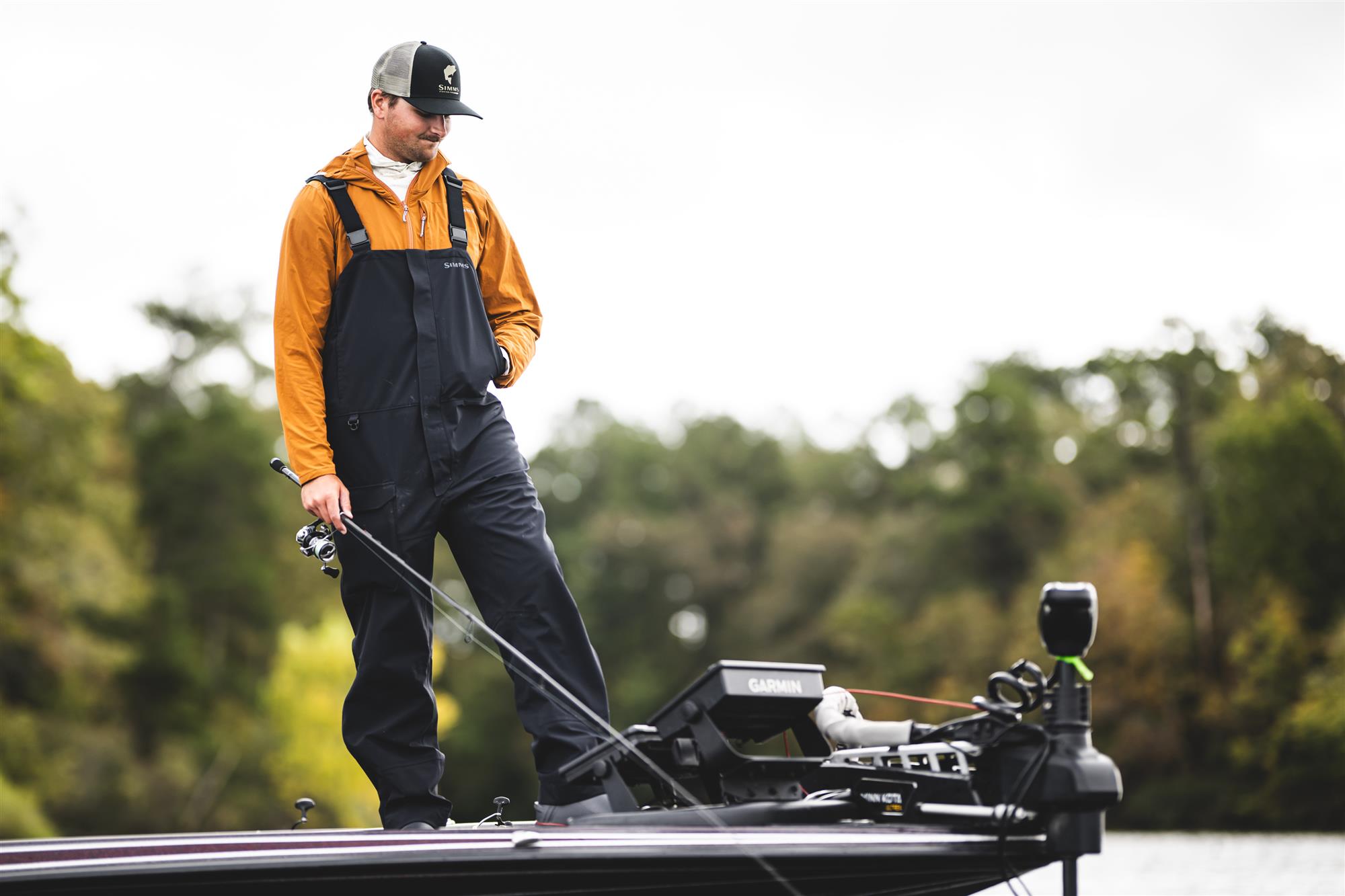Simms fishing bibs in action on boat deck waterproof breathable rain bibs fishing conditions