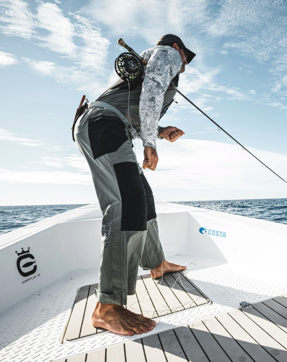 Angler wearing Simms Vapor Elite Bibs stripping fly line