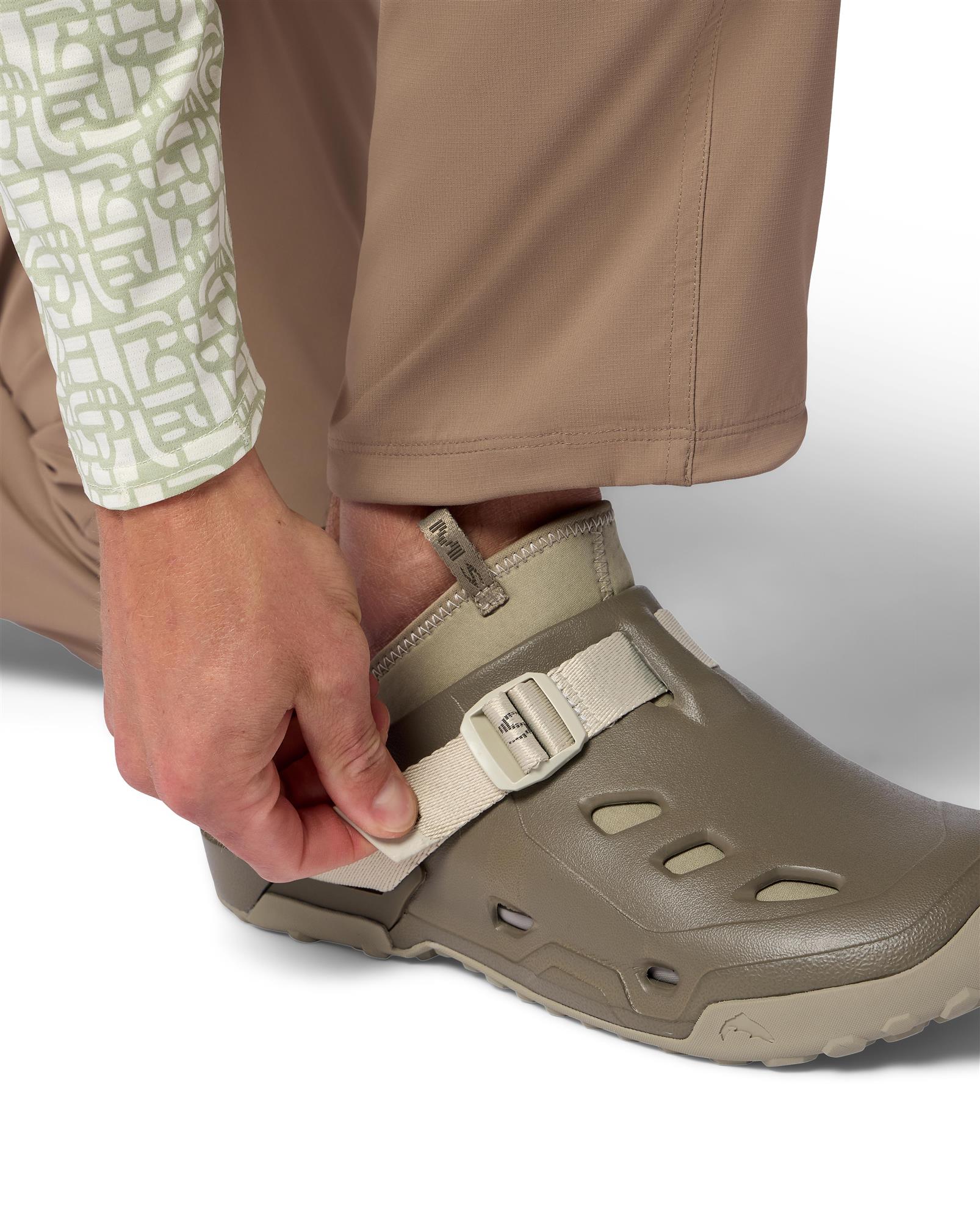 Angler tightening strap on Simms Drifter AT wet wading shoe with lightweight EVA upper and Ariaprene neoprene liner