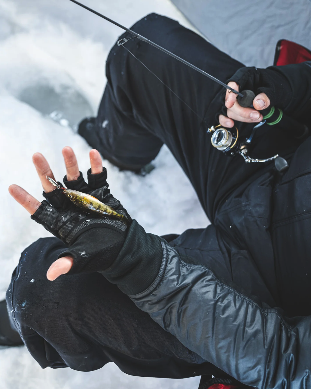 Ice angler holding perch on Simms Windstopper Half-Finger Fishing Glove