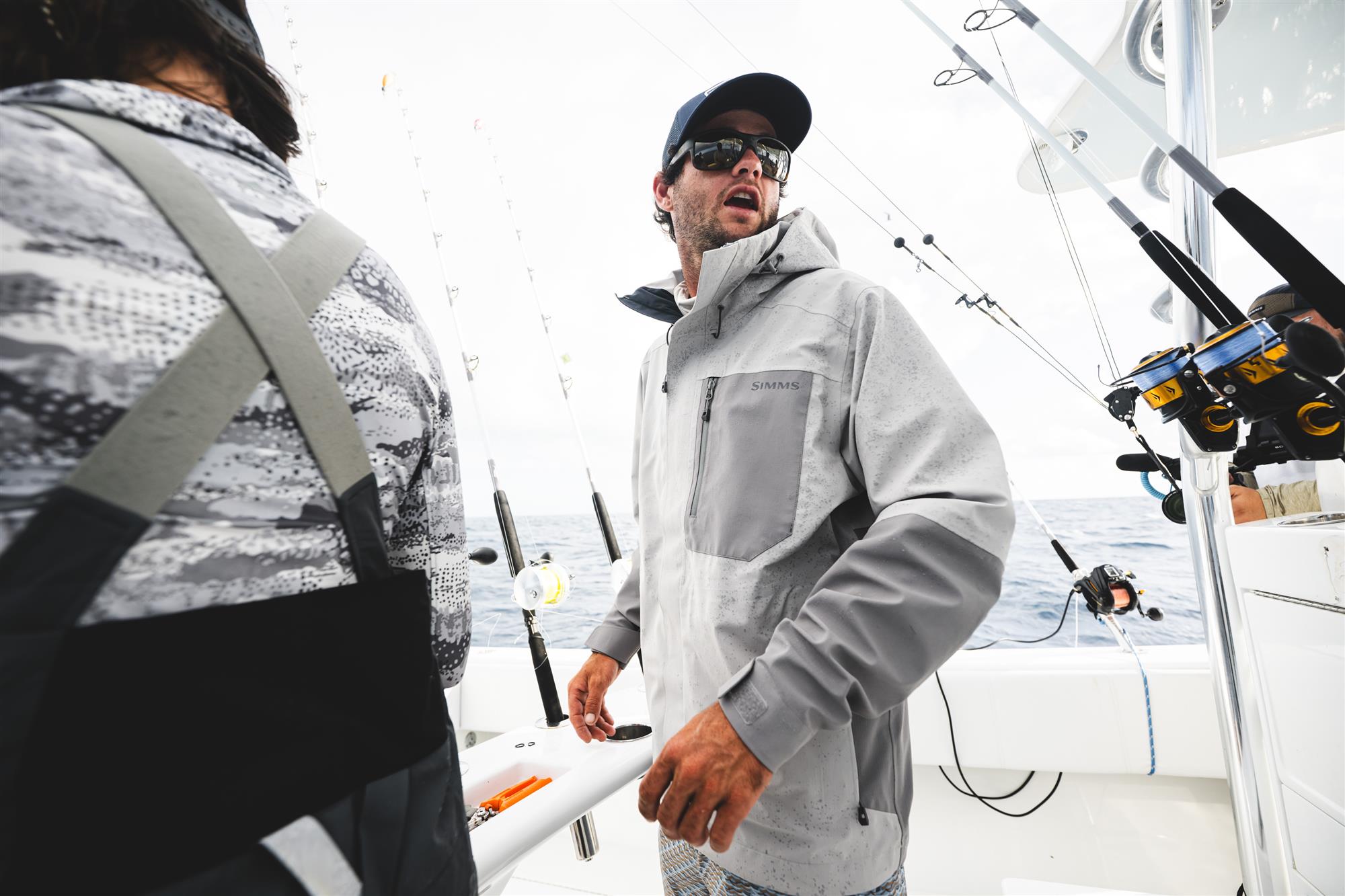 Simms Challenger waterproof fishing rain jacket worn by angler on offshore boat in wet conditions