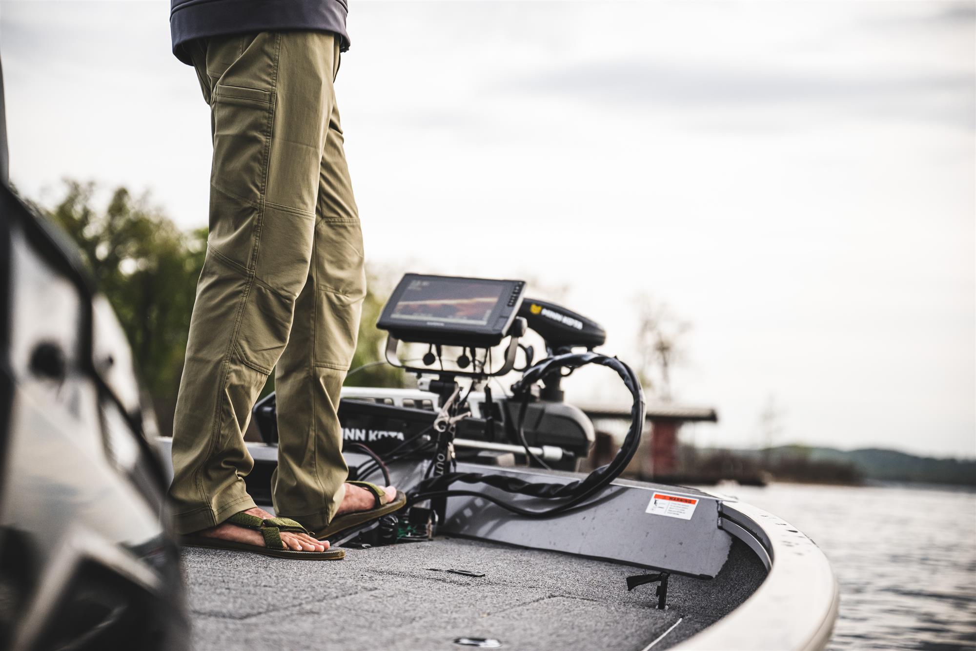 Simms Rogue Softshell Pants on boat deck lightweight insulated fishing pants for cold weather