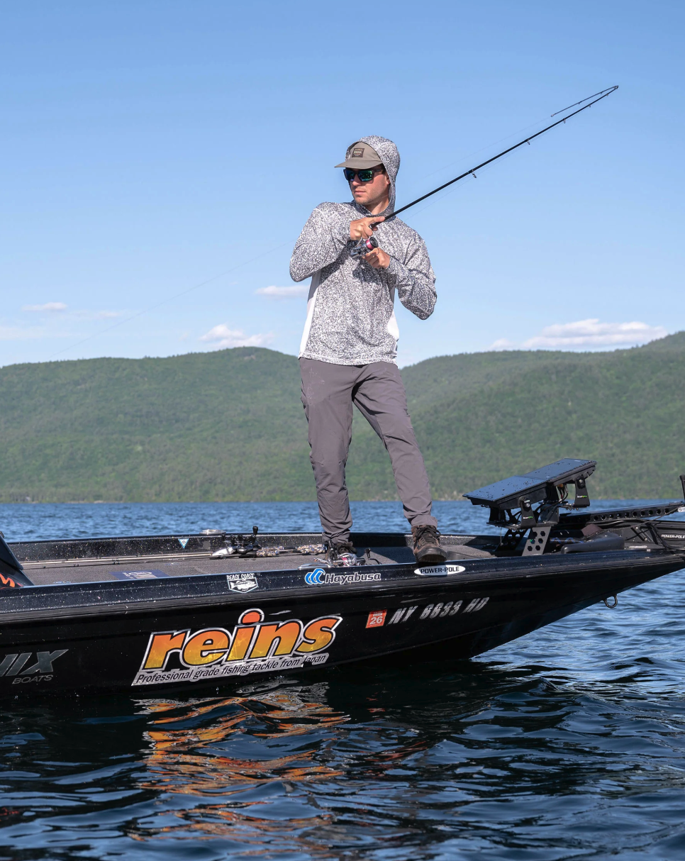 Man fishing in boat wearing Simms Challenger Solar Hoody